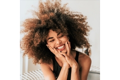 A smiling woman with curly hair.